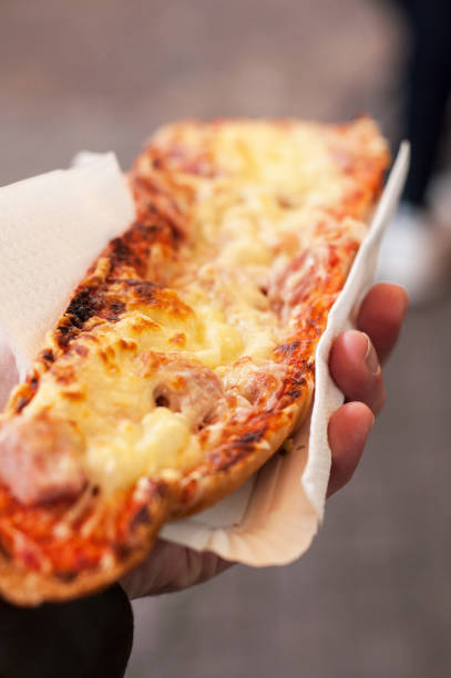 man-hand-with-pizza-in-bread-in-the-street.jpg
