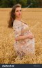 beautiful-young-pregnant-woman-in-a-dress-middle-of-wheat-fields-342050786.jpg
