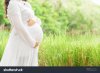 stock-photo-pregnant-woman-carry-her-belly-with-love-and-care-in-fresh-garden-504481003.jpg