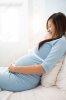 40935462-Asian-pregnant-happy-Woman-sitting-on-the-bed-smiling-Stock-Photo.jpg