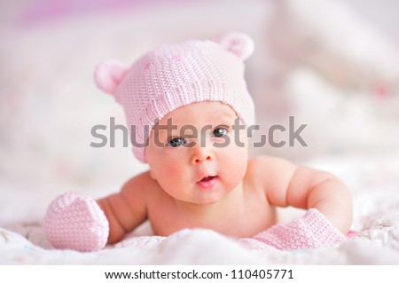 stock-photo-newborn-baby-girl-in-pink-knitted-bear-hat-and-mittens-on-a-bed-110405771.jpg
