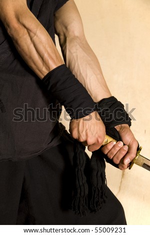stock-photo-muscular-forearms-of-a-martial-artist-samurai-warrior-with-a-natural-wood-background-55009231.jpg