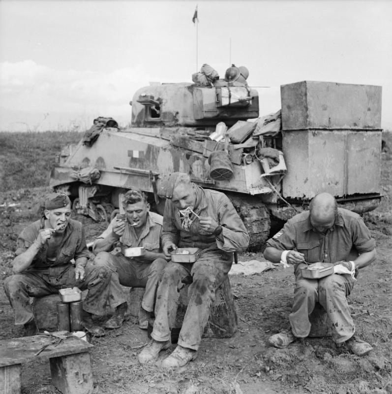 The-crew-of-a-Sherman-tank-fitted-with-deep-wading-equipment-enjoy-an-evening-meal-beside-their-vehicle-15-October-1943..jpg