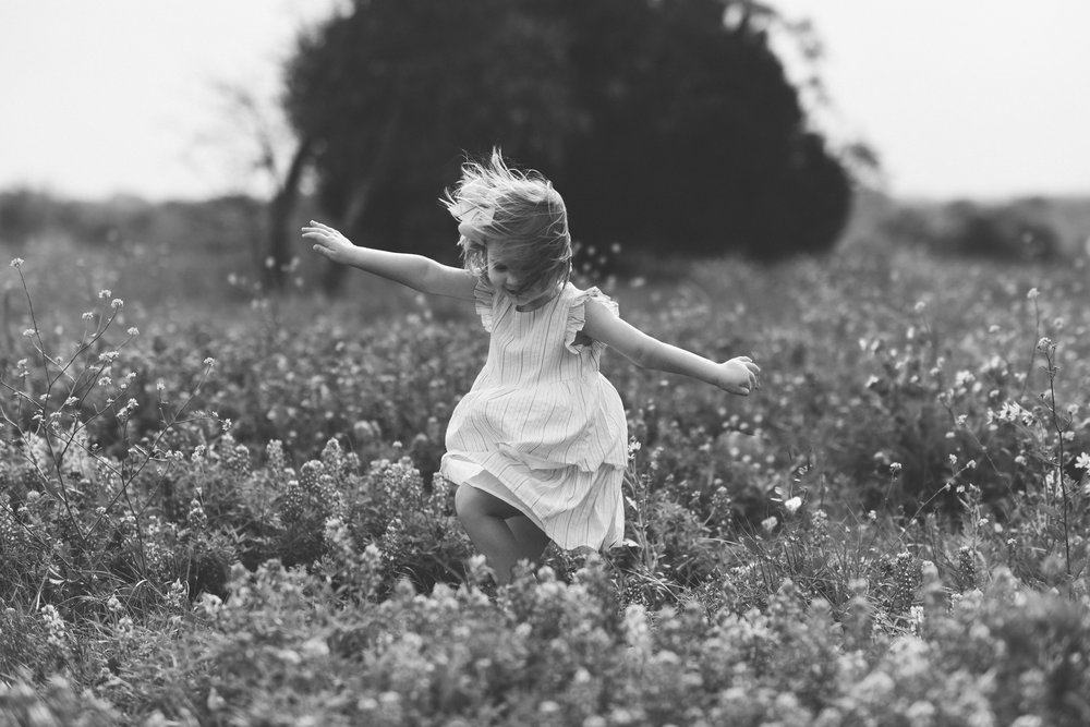 little+girl+dancing+in+wildflowers+with+open+arms.jpg