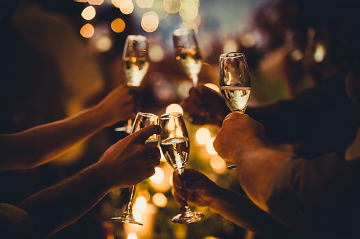 birthday-celebratory-toast-with-string-lights-and-champagne-picture-id1298329918