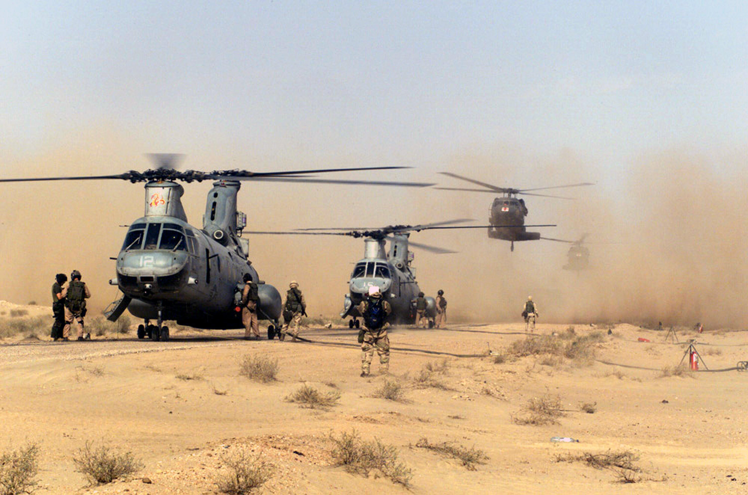 US_Navy_030325-M-3368I-005_Two_CH-46%27s_Sea_Knights_and_a_UH-60_Blackhawk_land_on_a_hardball_road_near_the_airstrip_at_Jalibah_to_take_on_additional_fuel_before_continuing_their_mission_northward.jpg